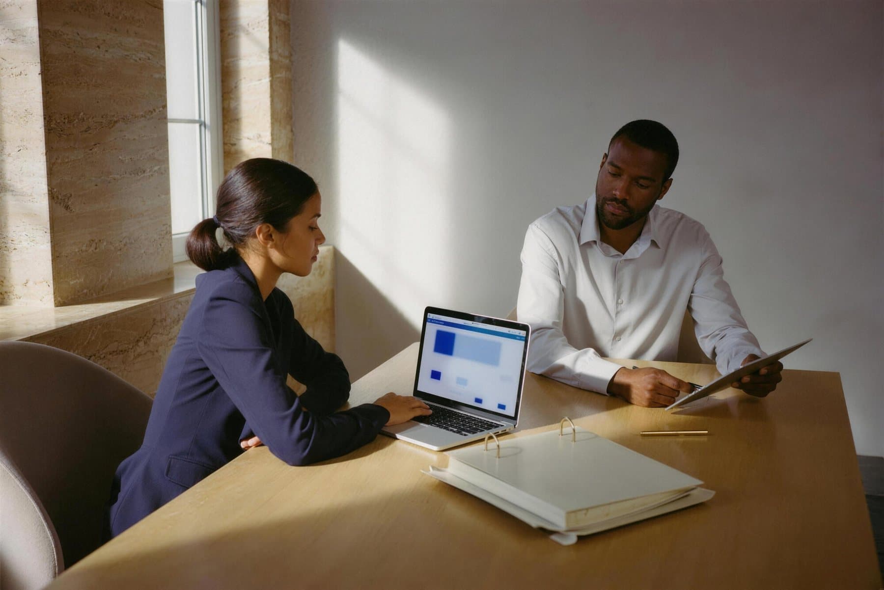 Dos personas planifican una jornada de salud sobre una mesa con planos y una laptop